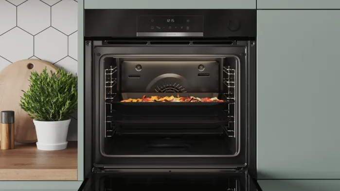 Geöffneter Bosch-Backofen mit Air-Fry-Blech und knusprig zubereiteten Speisen.