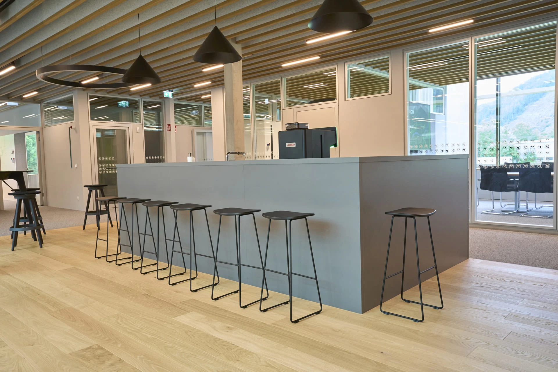 Bar- und Aufenthaltsbereich im Komptech Headquarter mit Sitzgelegenheiten und moderner Arbeitsumgebung