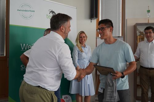 Zwei Männer geben sich die Hand, einer gratuliert dem anderen zur bestandenen Lehrabschlussprüfung