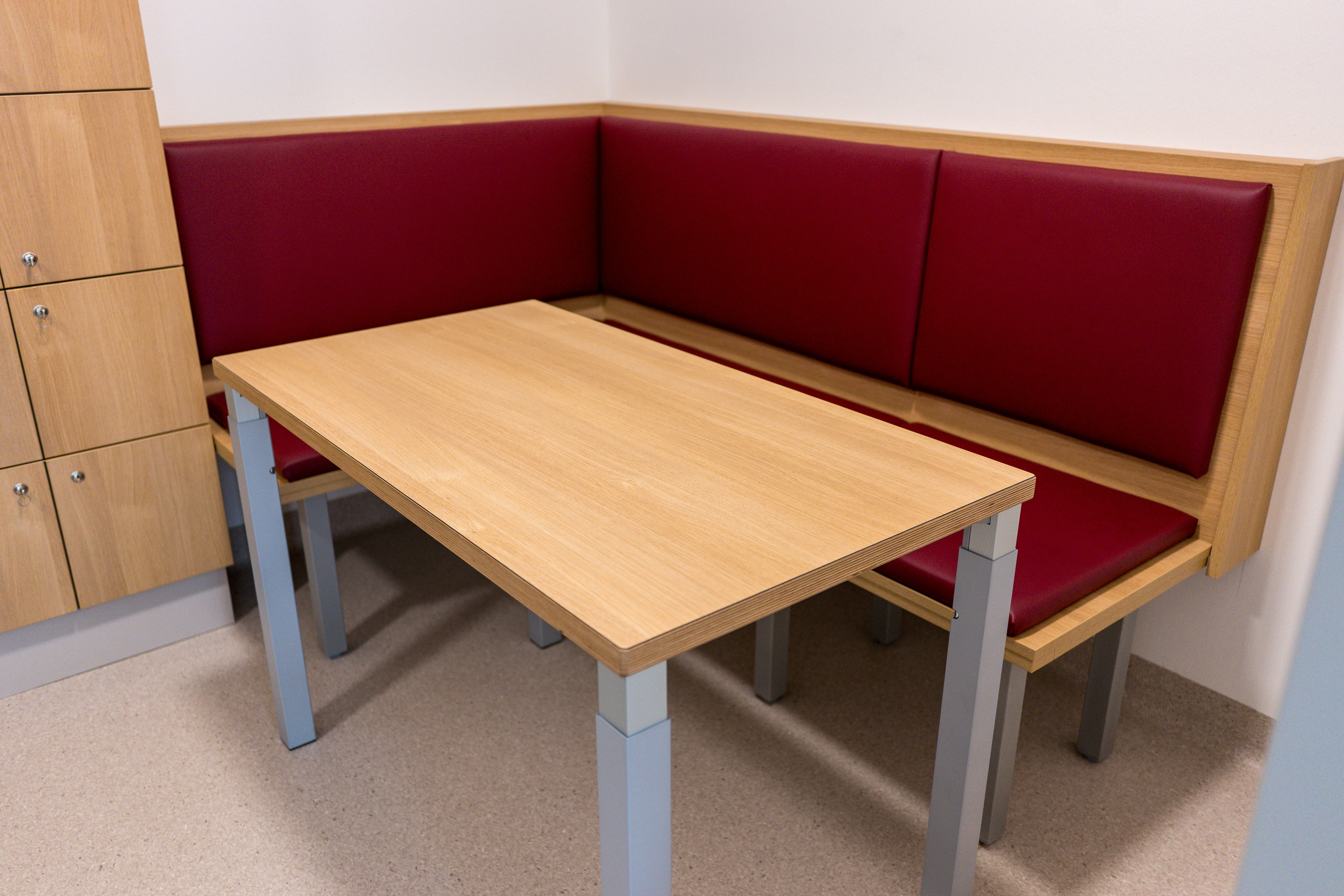 Eckbank mit roten Bezügen und einem Tisch