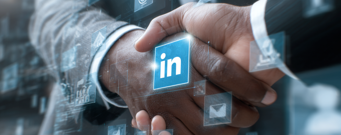 Two professionals in business attire shaking hands with LinkedIn logo at center, symbolizing B2B networking and LinkedIn advertising