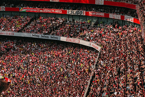Packed stadium crowd with visible advertising boards, illustrating the impact of in-stadium signage and media for sports marketing and fan engagement.