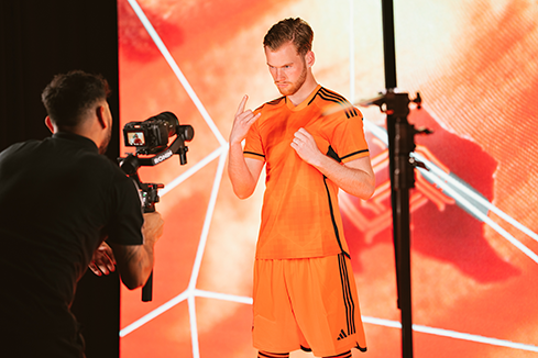 Athlete posing in a branded uniform during a video shoot, showcasing digital and social sponsorships that connect teams, players, and fans online.