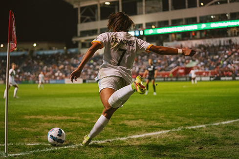 Soccer player taking a corner kick in front of a packed stadium, symbolizing precision, teamwork, and the impact of sales enablement tools in driving performance.