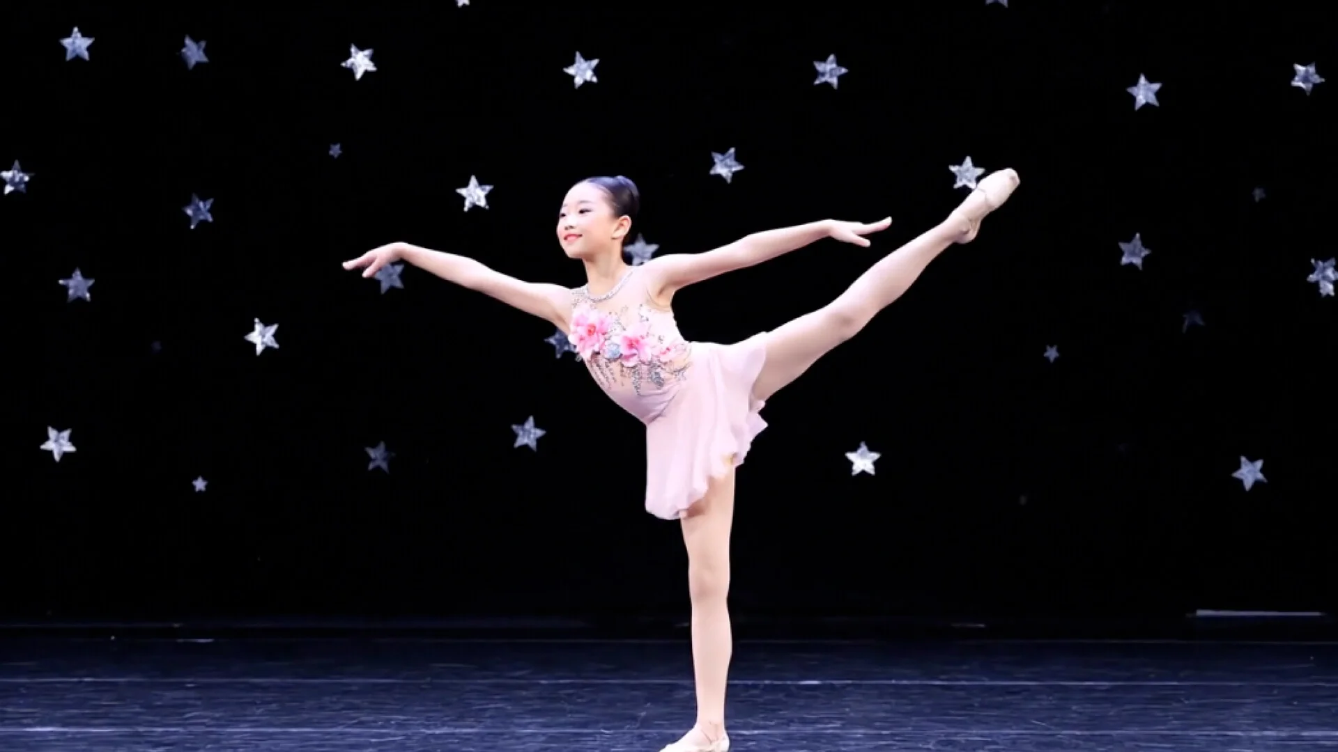 MUD Foundation Maya Man’s StarQuest, 2025, featuring a ballet dancer in a pink costume performing an extended leg pose on a stage against a black backdrop covered with stars.
