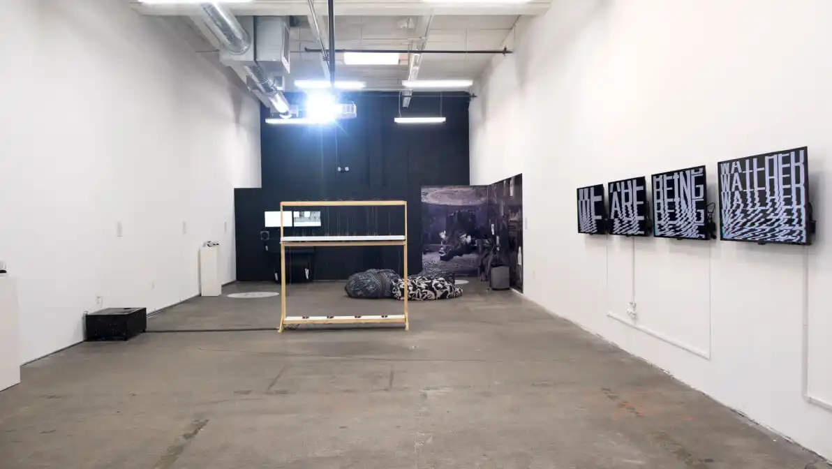 MUD Foundation MUD 2.0 exhibition, featuring a contemporary gallery installation with digital artworks displayed on wall-mounted screens, a central interactive structure, and large-scale artworks in the background.