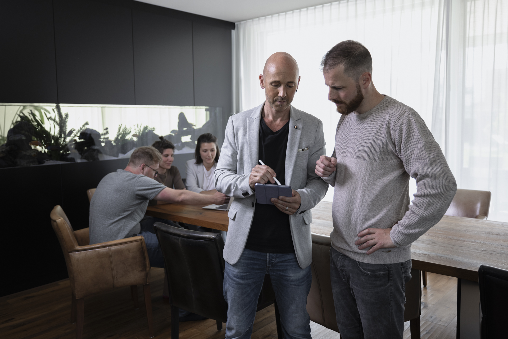 Zwei Männer präsentieren SEO Inhalten vor einem Whiteboard mit Bildern und Grafiken zur Veranschaulichung wichtiger Informationen eines Shopify Stores