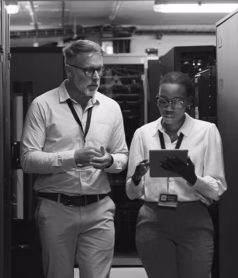 Two computer forensic analysts work in a server room