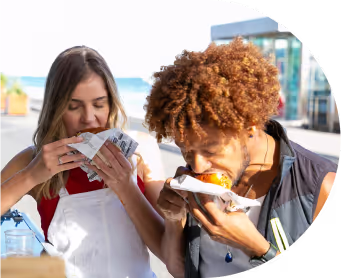 Young diverse couple having lunch with junk food
