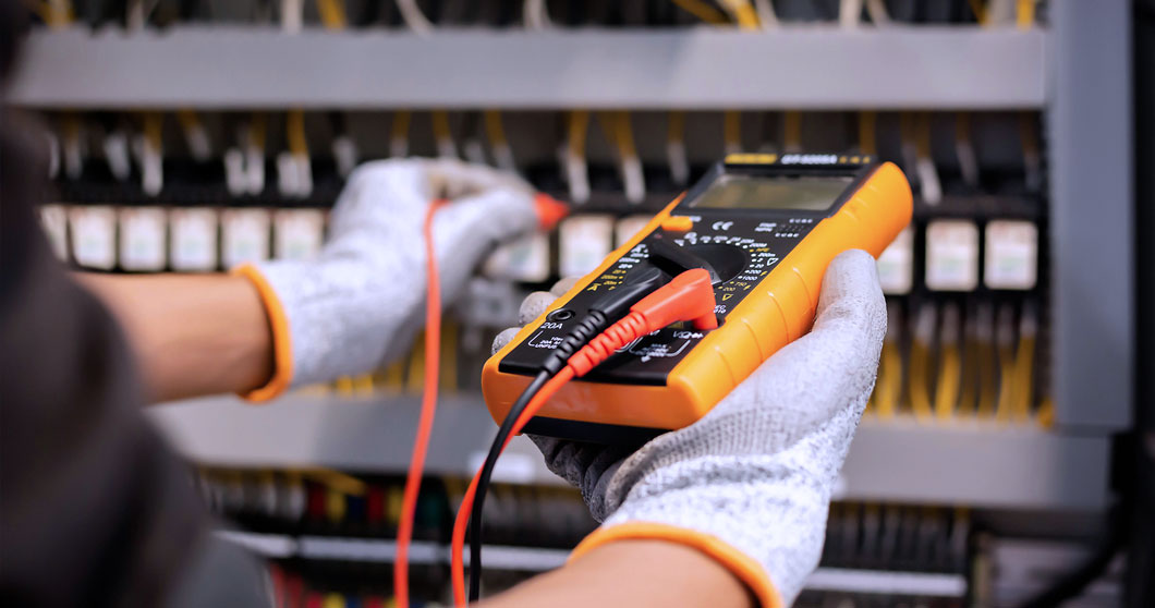 Photo of an electrician measuring electrical capacity with a multimeter