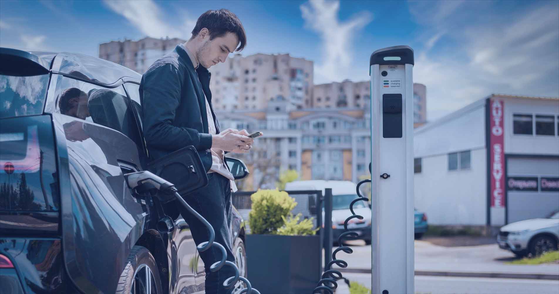 Photo of a man charging his EV outside his apartment building