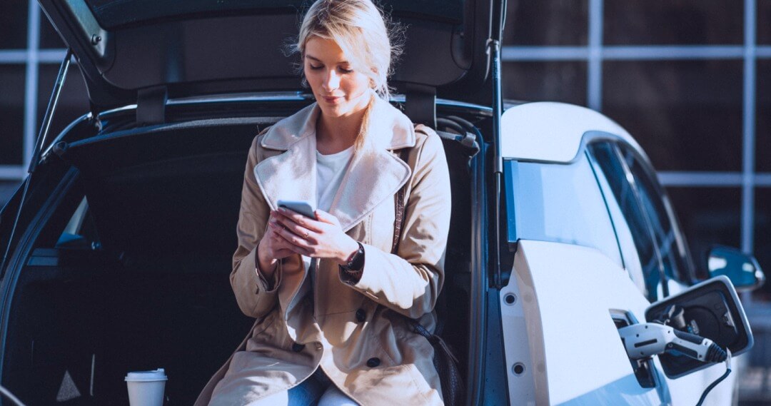 EV driver using the AmpUp app to pay for EV charging at a retail location