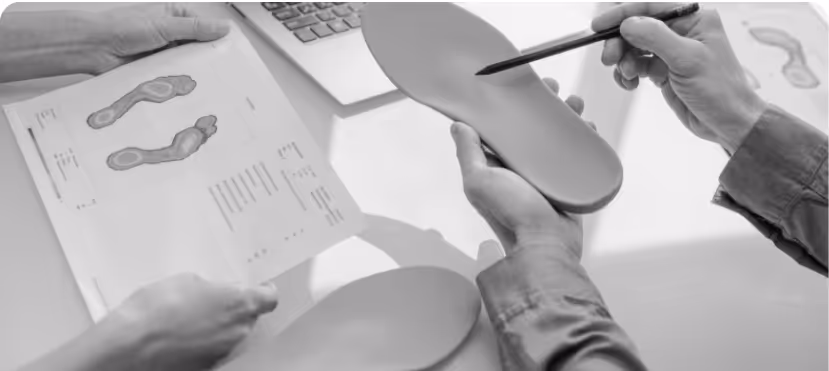 This image is representing Orthotics practice where the doctor is pointing to the insole and checking out the clients results from some testing 