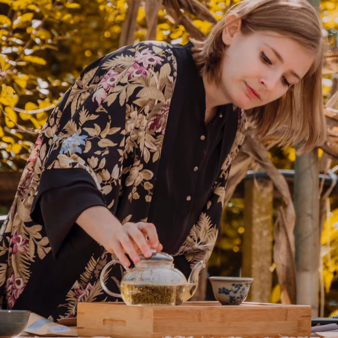 ragazza che prepara del tè in una teiera di vetro