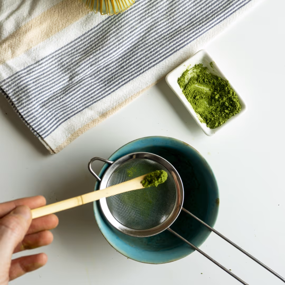 mano che misura un cucchiaino di matcha