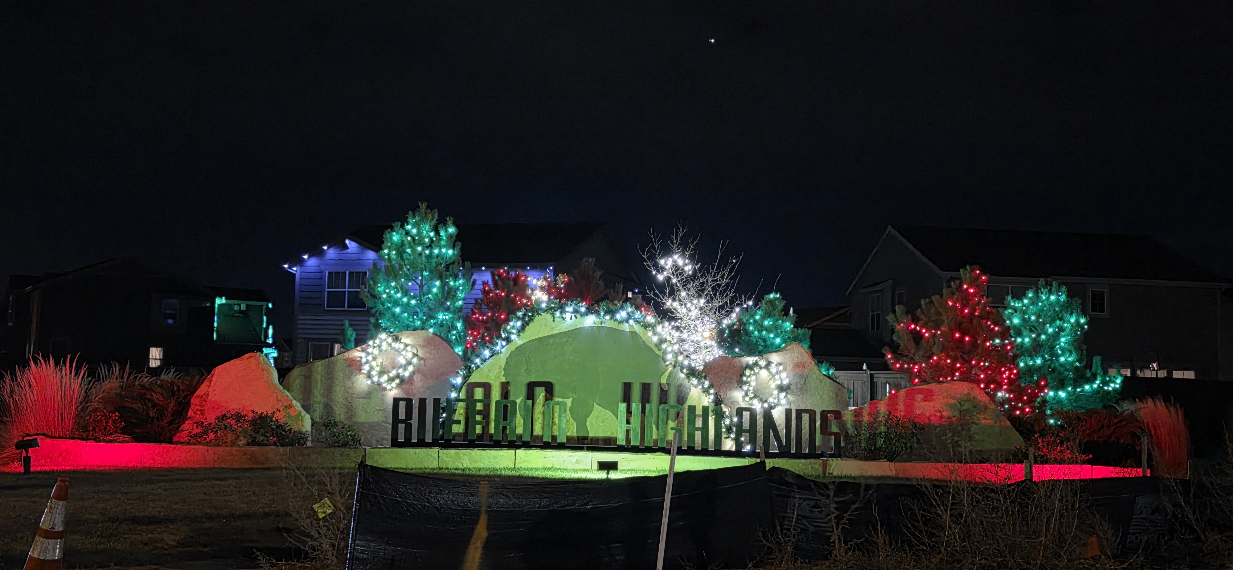 Buffalo Highlands community entrance with professionally installed red, green and white holiday lighting