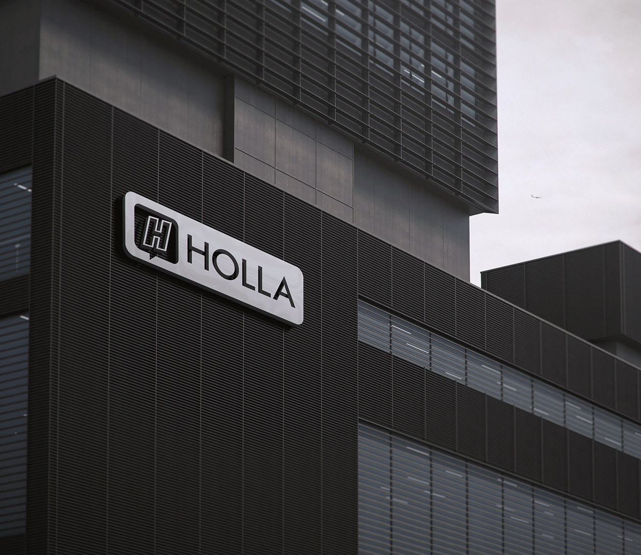 A modern building with the a Holla logo on the side.