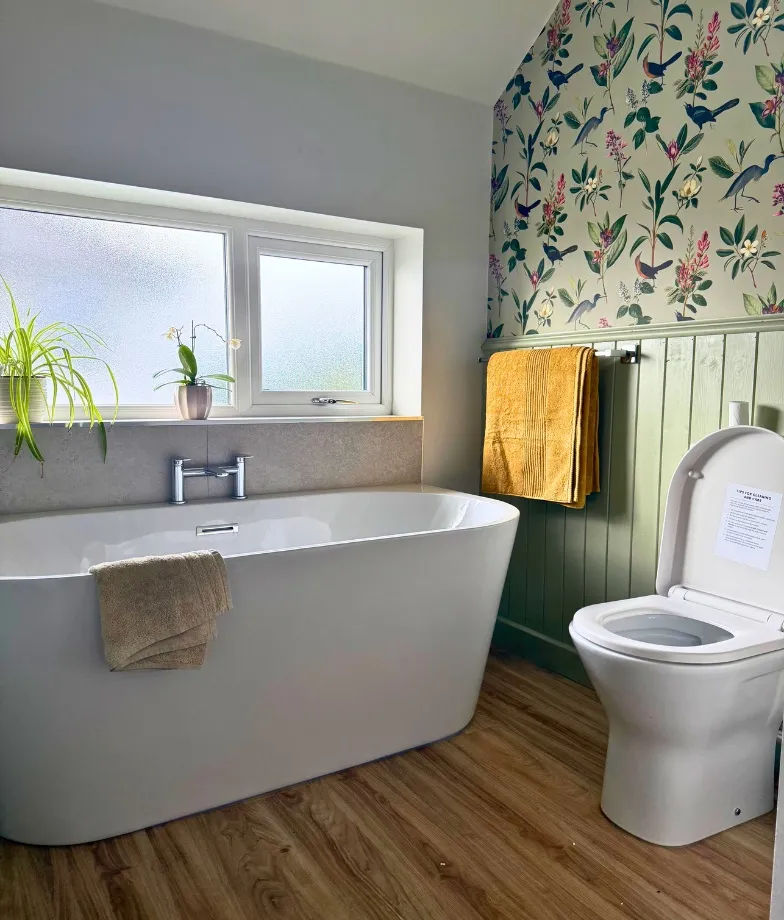 Floral bathroom with soft flower-patterned wallpaper and elegant design