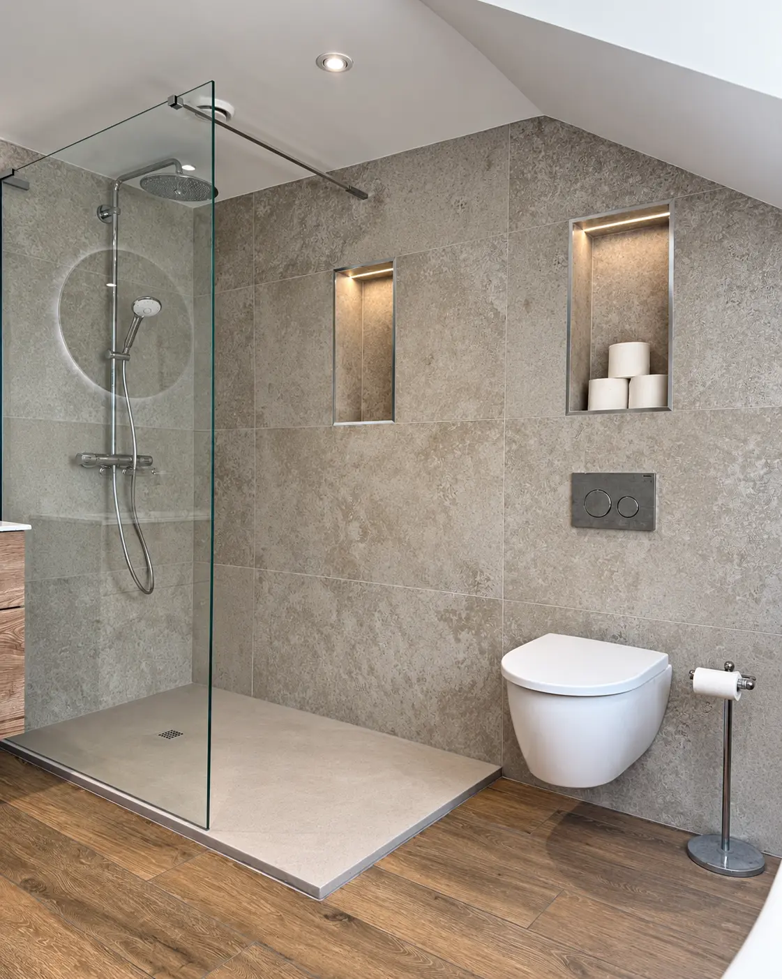 Walk-in shower and wall-hung toilet with illuminated recessed niches