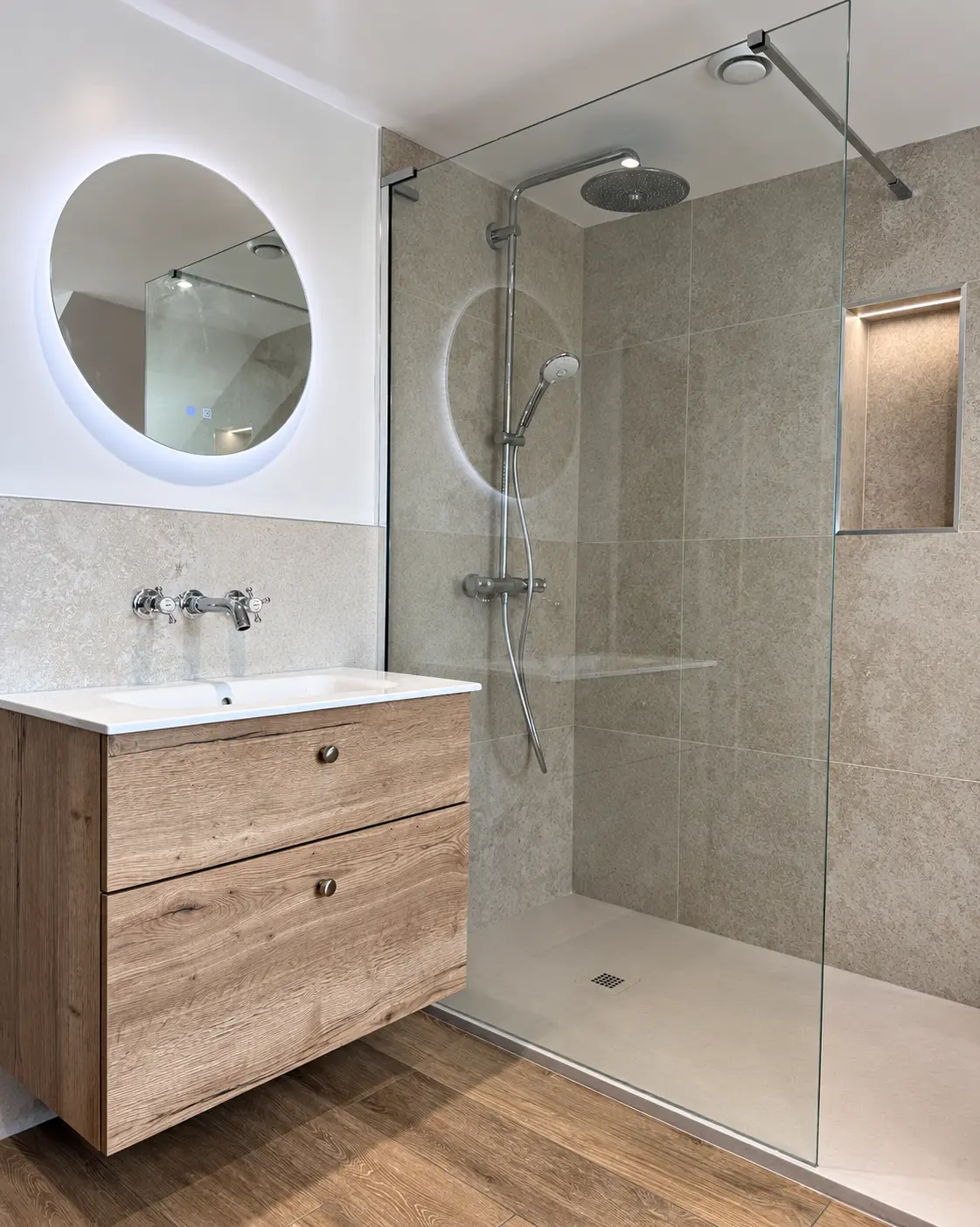 Floating wood-effect vanity beside a frameless walk-in shower