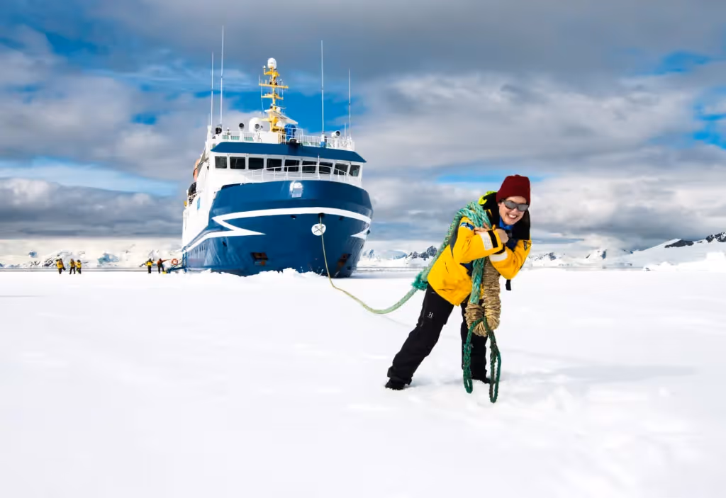 How to Visit Antarctica? Sandra Walser in Antarctica, with Ocean Nova in the background