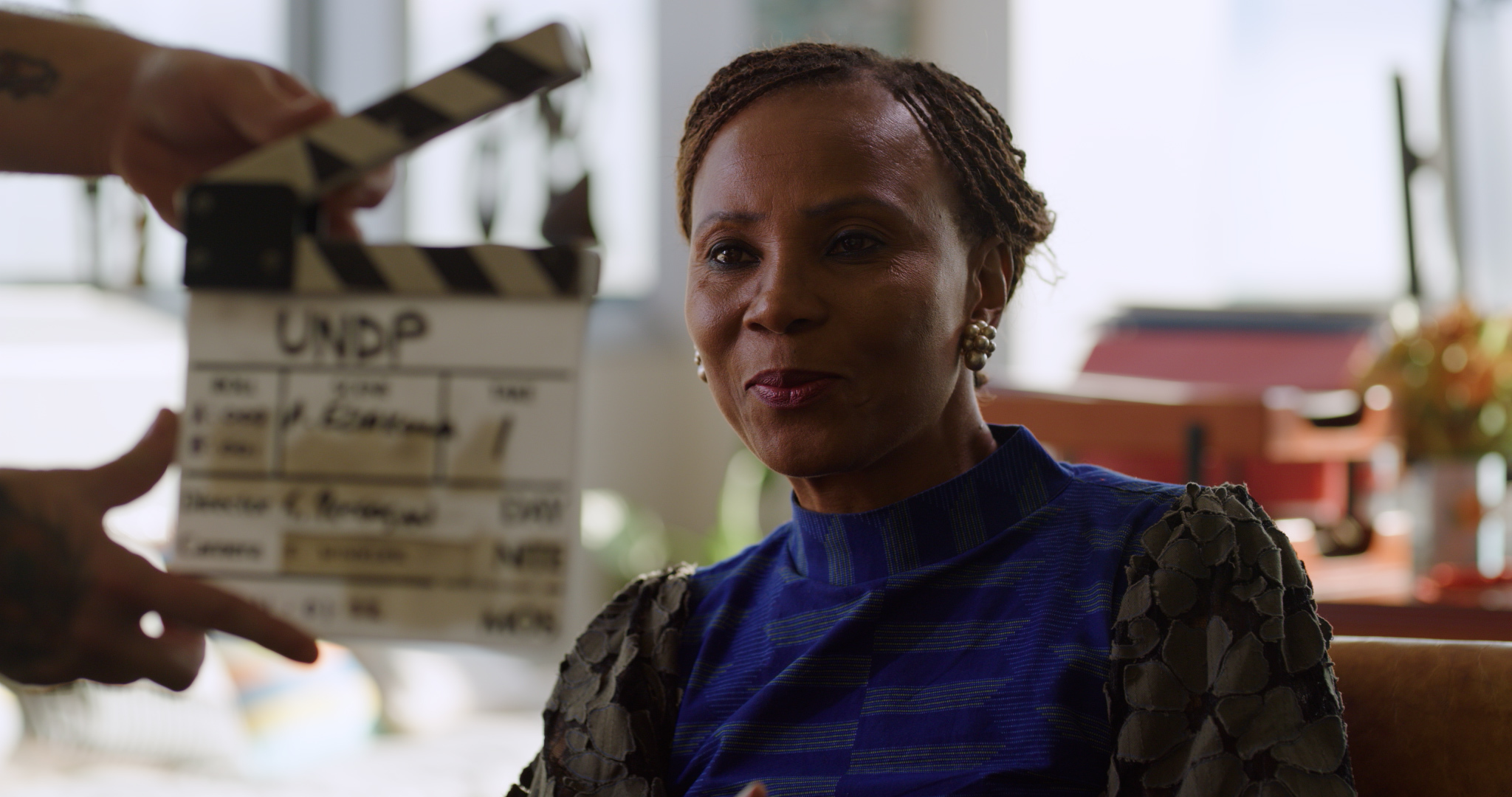 A person with a film clap board in front of them