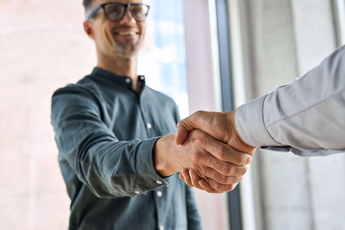 Customer shaking hands with tech professional.