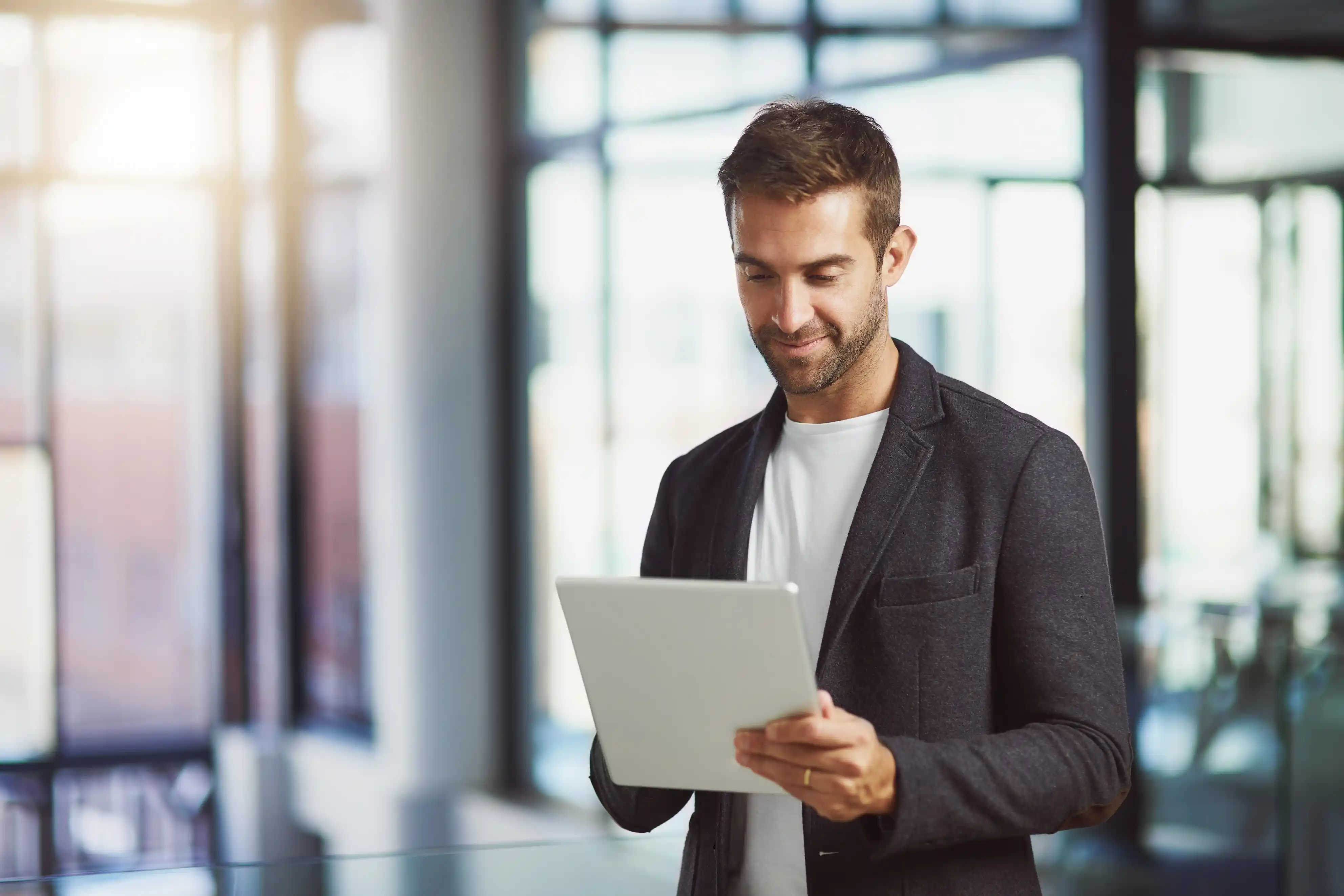 Corporate, research and businessman with tablet in office for investment, feedback and finance review. Company, financial advisor and typing with tech for stock report, email or update on share price