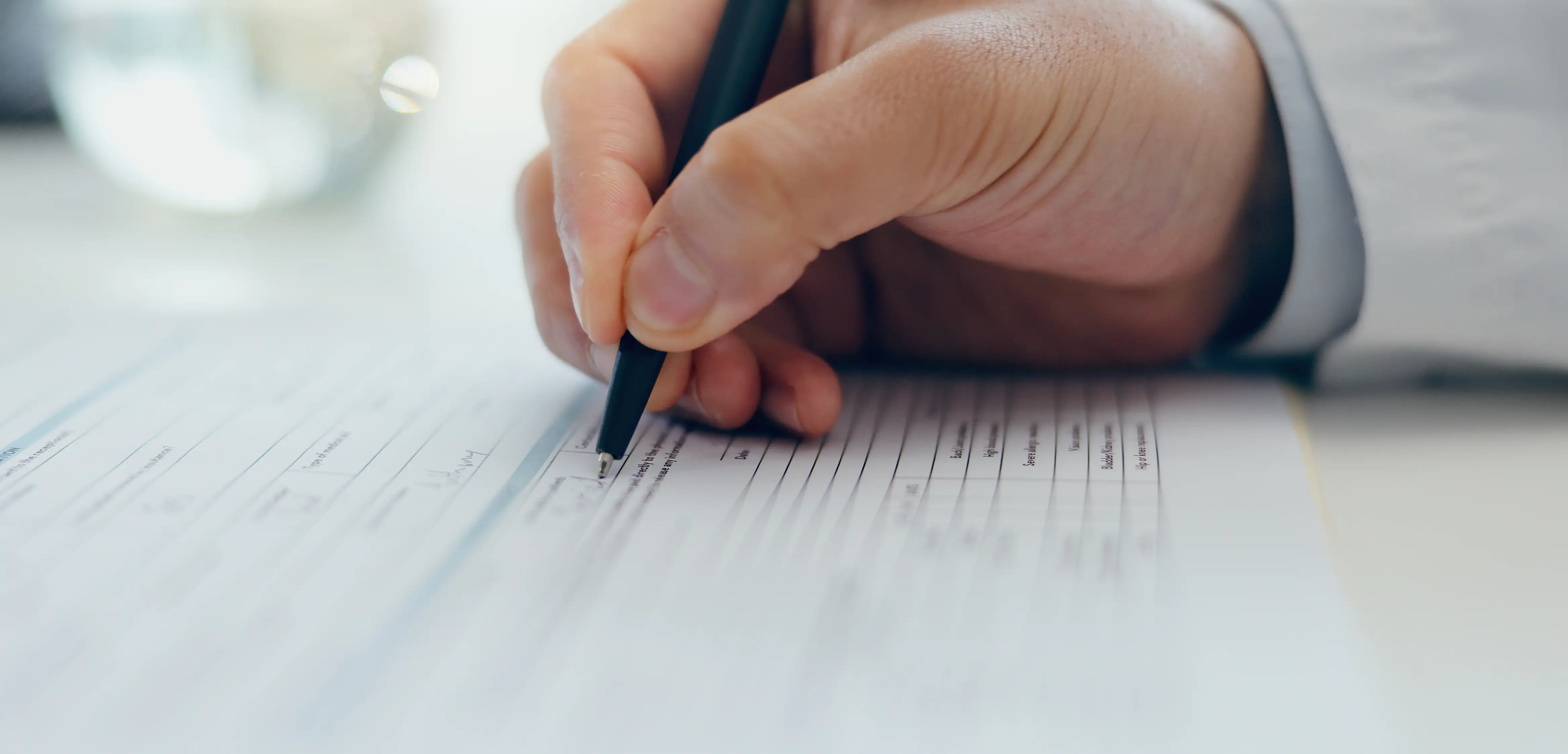 Doctor, hands or writing with document for signature, application or information on desk at hospital. Closeup of healthcare employee filling in form, paperwork or signing for medical aid or insurance