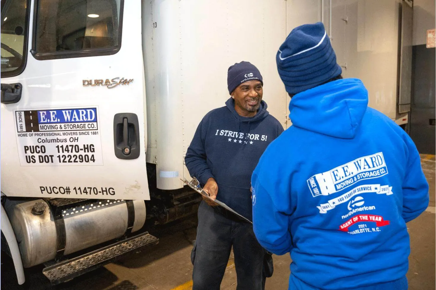 Movers helping middle age woman move into a new home