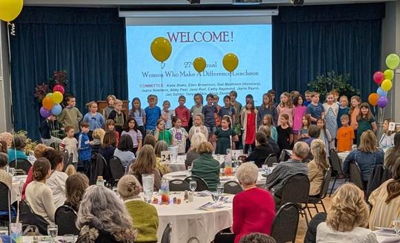 Photo of elementary school student singing at luncheon