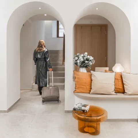 Photo d’un client avec valise à la réception de l’Hôtel de la Cigogne, illustrant l’expérience d’accueil premium imaginée par Momerable.