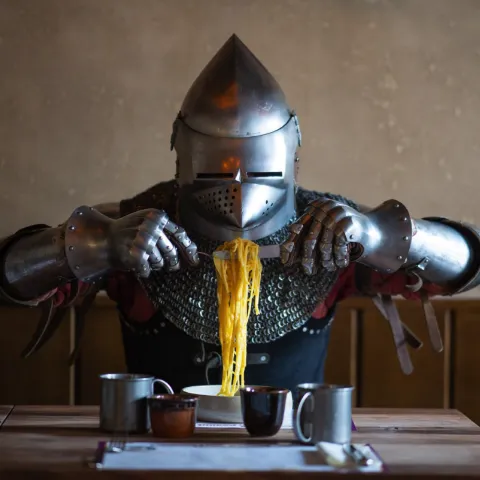 Photo d’un client déguisé en chevalier en train de manger, illustrant l’expérience ludique et thématique développée par Momerable pour Peanut Medieval.