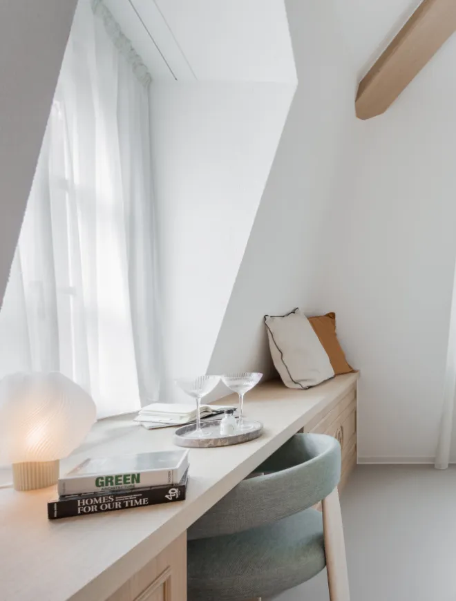 Photo de verres et de livres posés dans une chambre élégante, illustrant une atmosphère chaleureuse et accueillante signée Momerable.