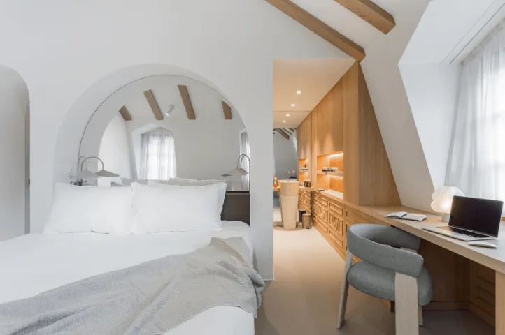 Photo d’un lit élégamment dressé à l’Hôtel de la Cigogne, mettant en valeur l’atmosphère chaleureuse et patrimoniale conçue par Momerable.