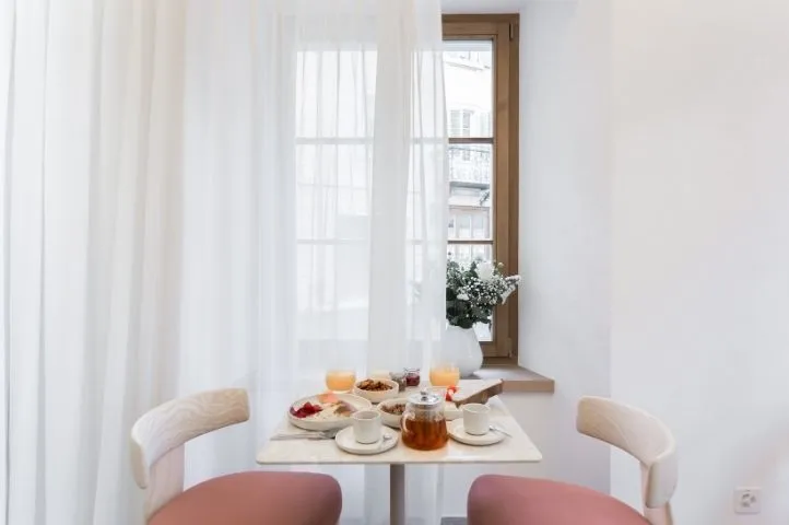 Photo d’une table de petit déjeuner raffinée à l’Hôtel de la Cigogne, illustrant l’hospitalité haut de gamme développée par Momerable.