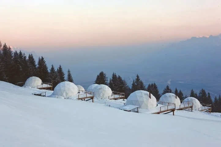Photo de dômes Whitepod recouverts de neige, symbolisant l’hébergement éco-responsable en pleine nature conçu par Momerable.