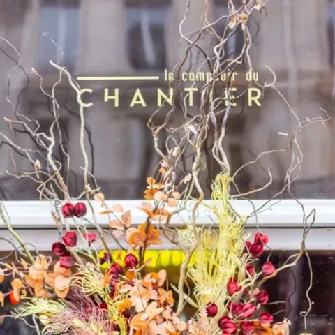 Photo de la vitre d’entrée du Comptoir du Chantier avec le logo, illustrant l’identité visuelle et le positionnement original développés par Momerable.