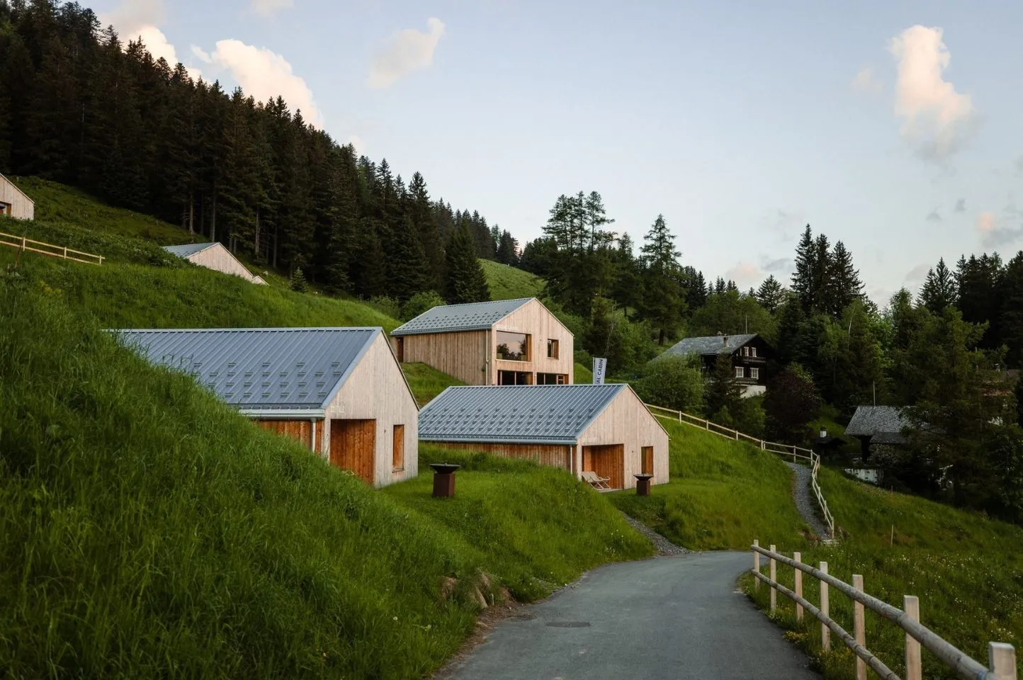 Photo de plusieurs chalets Swiss Cabin alignés dans un paysage alpin, illustrant la modularité et la rapidité d’exécution du concept conçu par Momerable.