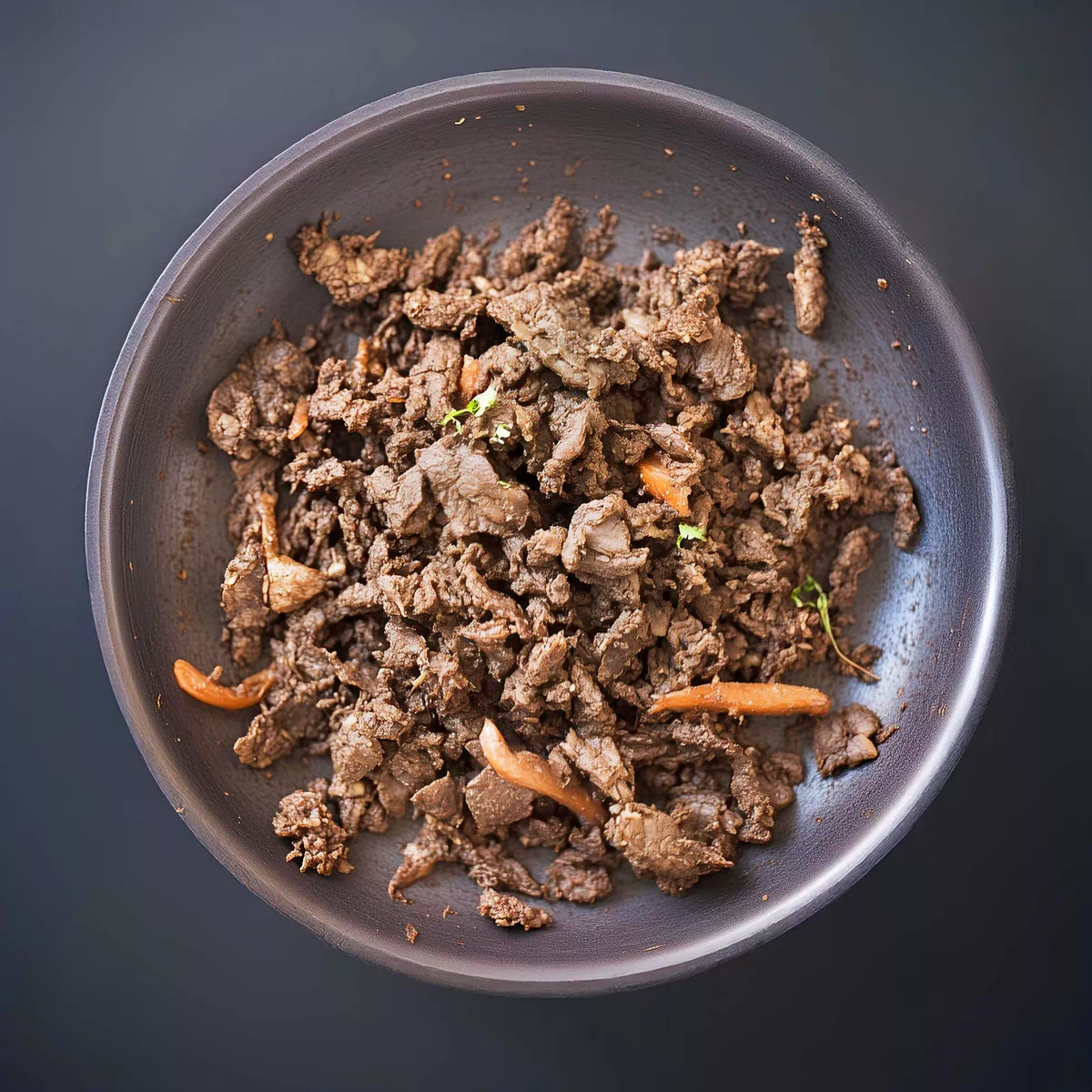 볶음 팬에 얇게 썬 소고기와 당근 조각이 있는 한국식 불고기.