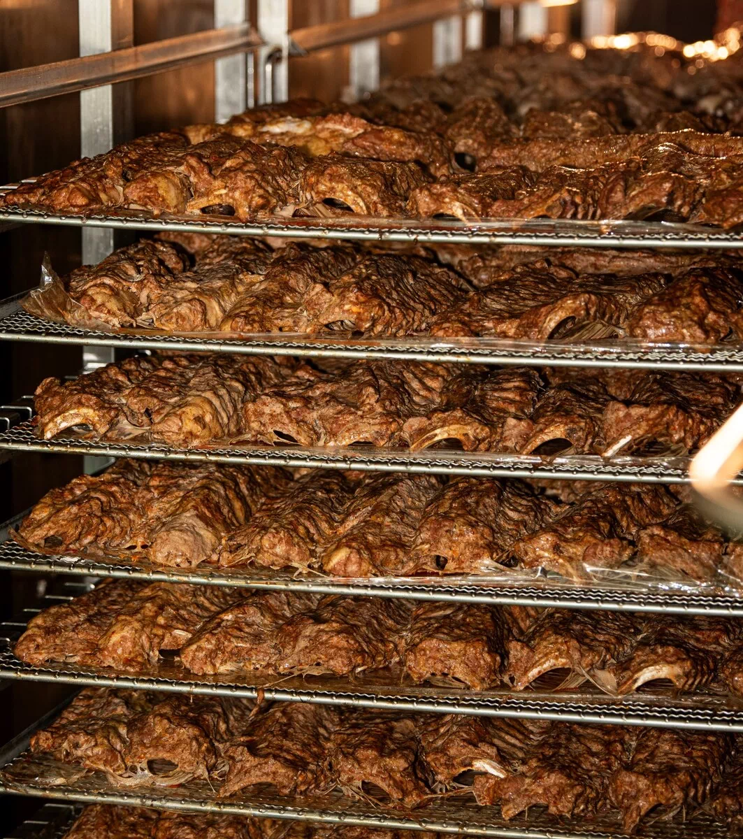 오븐 선반 위에 여러 층으로 쌓여 있는 잘 익은 바비큐 립.