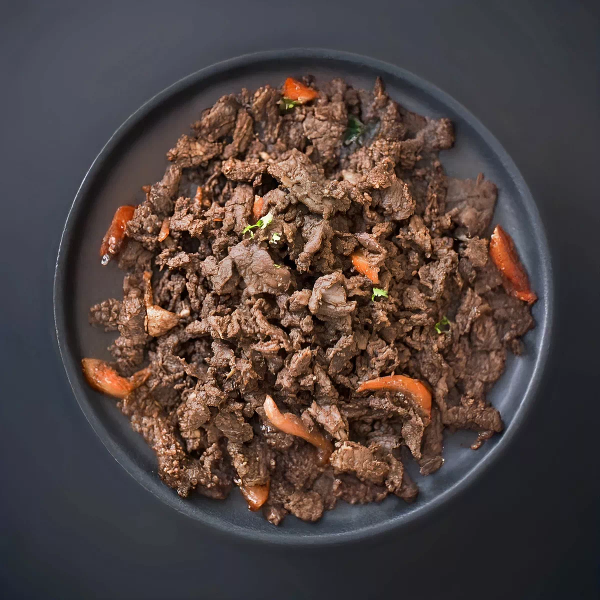 접시에 담긴 양념된 불고기와 당근 조각들.