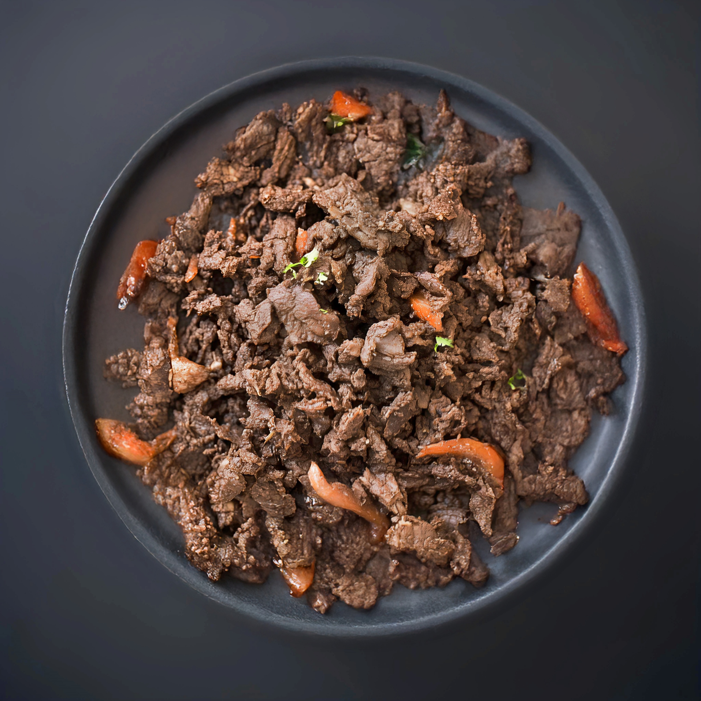 접시에 담긴 양념된 불고기와 당근 조각들.