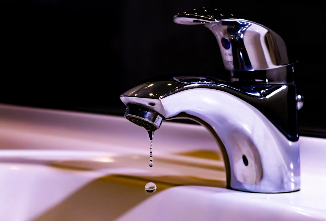 Professional plumber inspecting a Springfield home, checking under-sink pipes with a flashlight - how to spot plumbing Professional plumber inspecting a Springfield home, checking under-sink pipes with a flashlight - how to spot plumbing