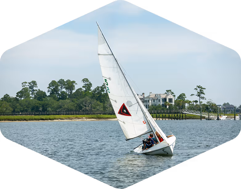Small sailboat with white sails on a sunny day