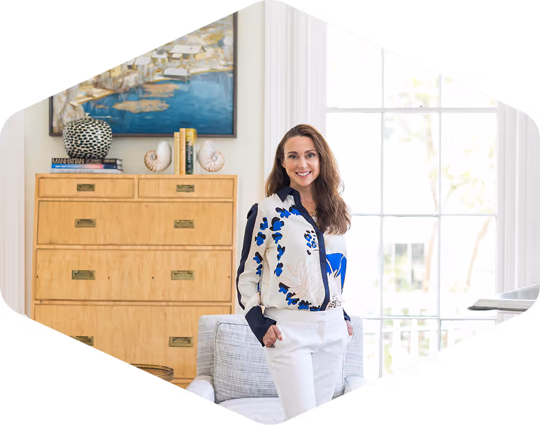 Woman posing in a large, ornately decorated room with large windows