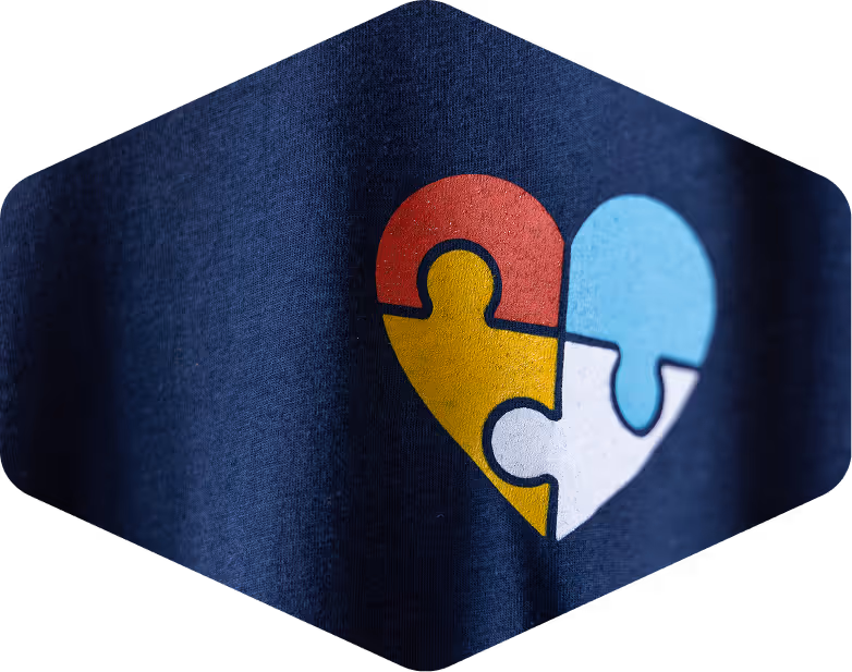 Heart-shaped Low Country Autism logo printed on a blue t-shirt