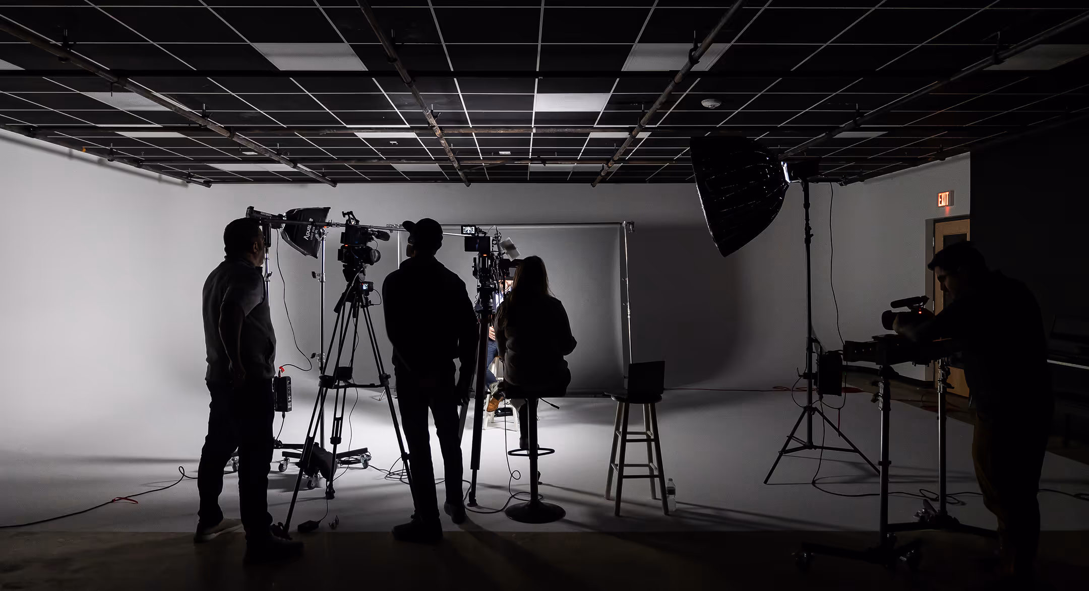 Three Target Market staff members planning for a photo shoot in a large studio filled with equipment