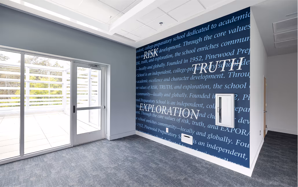Large wall displaying a mural promoting the values and history of Pinewood Preparatory School