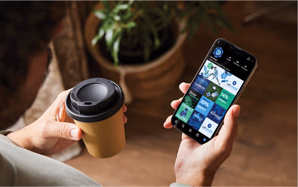 Man viewing Instagram grid featuring green and blue graphics from Life Wager problem gambling awareness campaign.